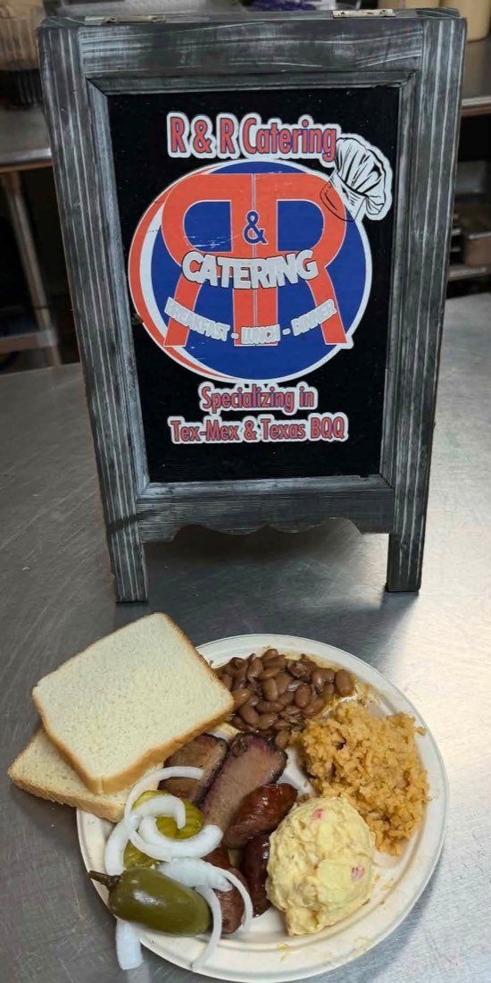 R&R barbecue plate with smoked meat, sausage, beans, Spanish rice, potato salad, bread, and pickles