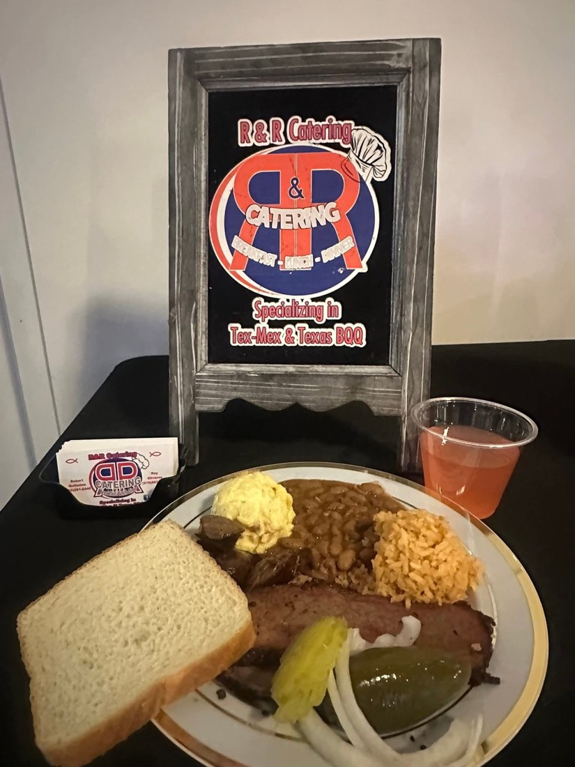 Barbecue plate with brisket, beans, Spanish rice, potato salad, bread, pickles, and onions
