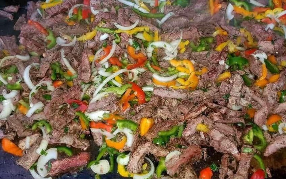 Grilled beef strips mixed with sliced onions and colorful peppers