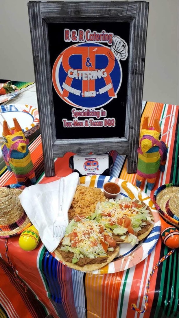 Tex-Mex plate with two topped tostadas, Spanish rice, and salsa beside an R&R Catering display