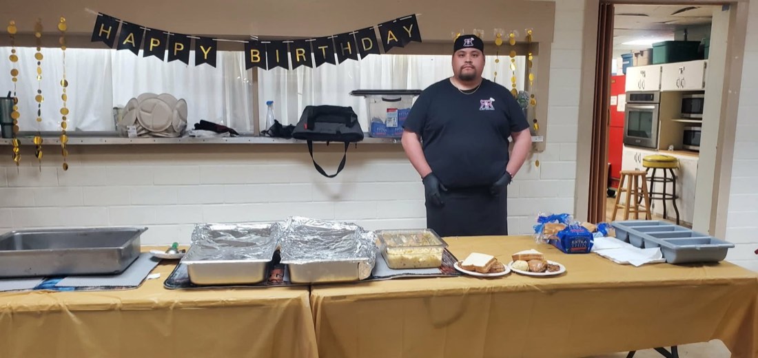 R&R Catering team member behind a buffet prepared for a birthday gathering