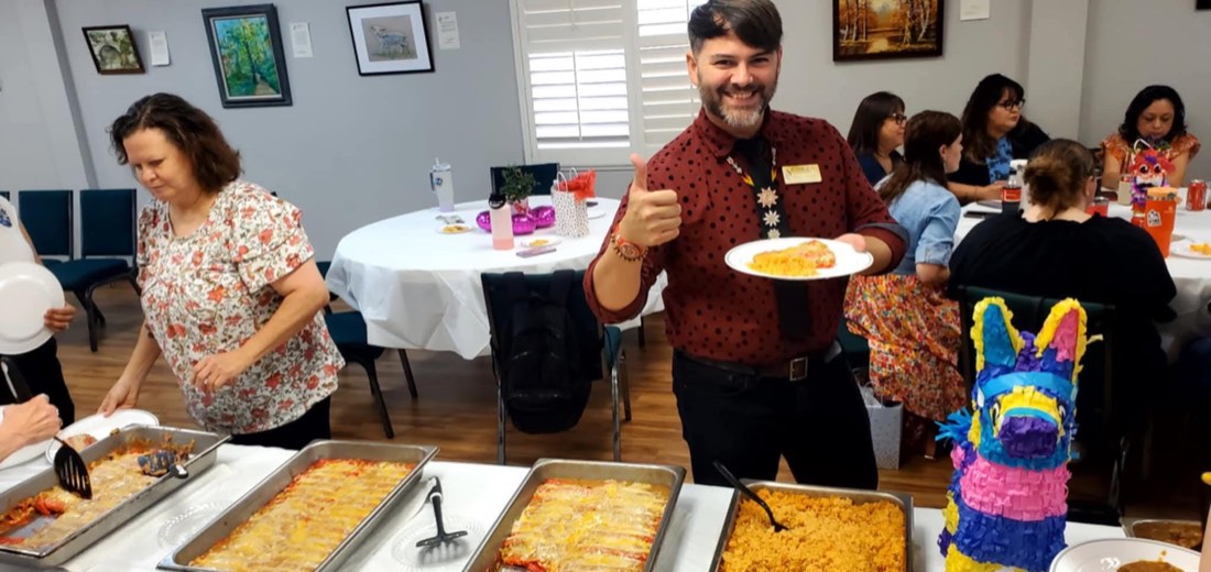 Guests serving themselves from a catered buffet while one guest gives a thumbs-up
