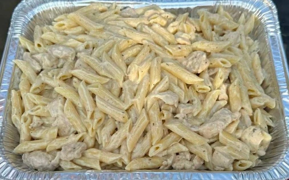 A catering tray of creamy chicken Alfredo penne